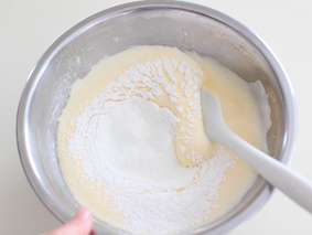 マフィンカップでミニデコケーキ　レシピ生地の一面に薄力粉を加え、切るように混ぜ合わせる